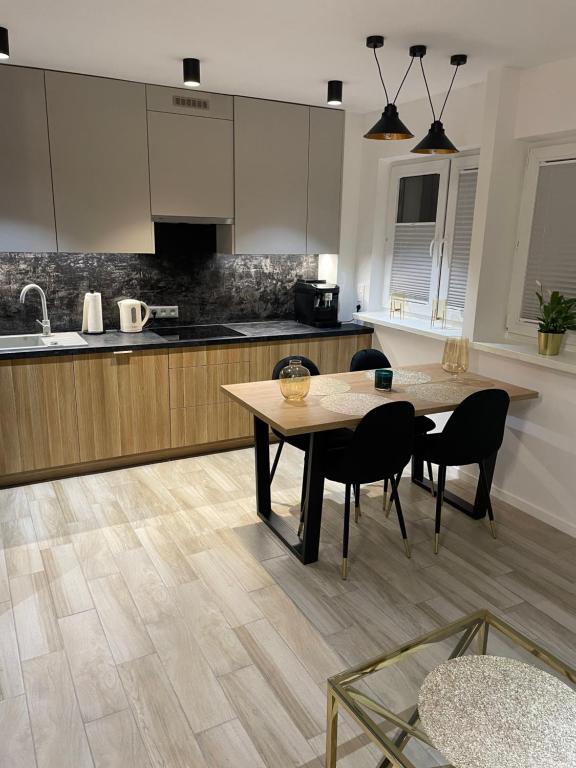 a kitchen with a table and some chairs and a counter at Brzostek Apartment in Warsaw