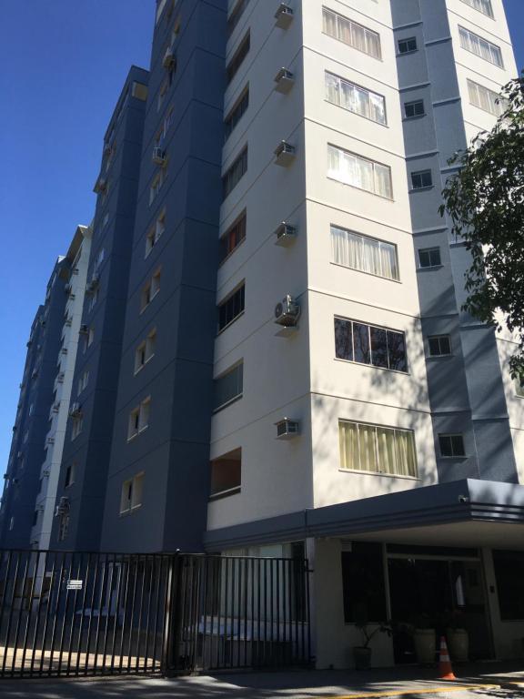 um edifício alto e branco com uma cerca em frente em Rio Quente - DiRoma em Rio Quente