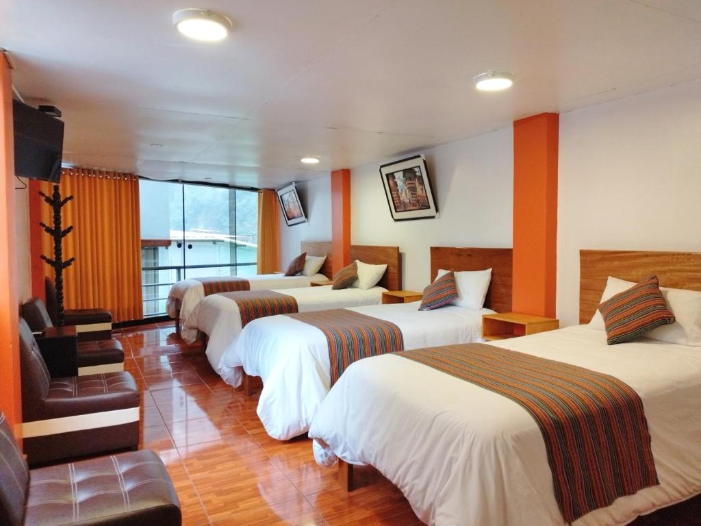 un grupo de 4 camas en una habitación de hotel en Amakonkay Machupicchu en Machu Picchu