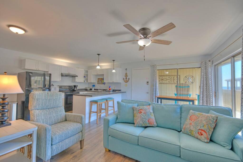 a living room with a blue couch and a kitchen at Living the Dream 2 Bedroom Ocean View Cozy Condo in Gulf Shores