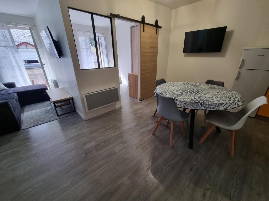 um quarto com uma mesa e cadeiras e uma sala de estar em Coeur de Cauterets appartement 53m² 4/6 personnes em Cauterets