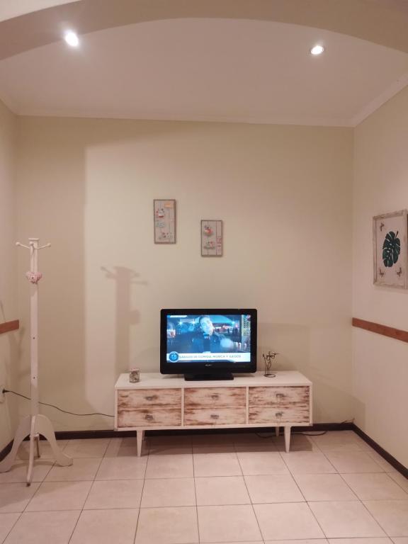 TV de pantalla plana en la parte superior de un armario de madera en Casa céntrica premium en San Pedro