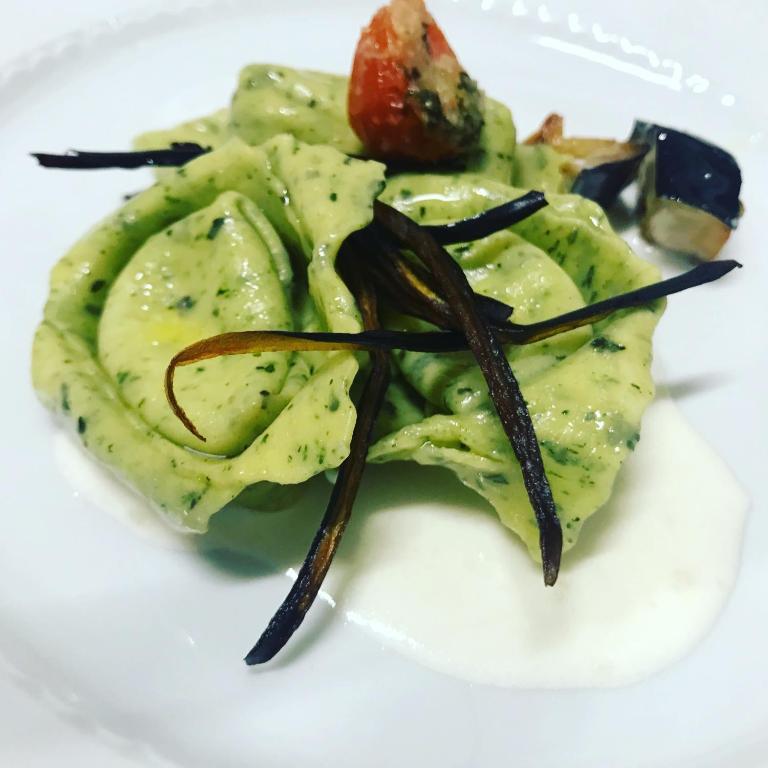 a white plate of food with avocado and a tomato at Masseria Valente in Ostuni