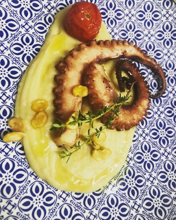 a plate of food with onion rings and a tomato at Masseria Valente in Ostuni