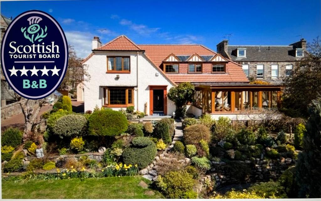 a house with a sign in front of it at Ailim House Serviced Cottage Escape, around the corner from the Old Course in St Andrews