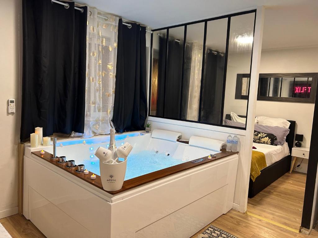 eine Badewanne in einem Zimmer mit einem Bett in der Unterkunft Love Room à Cannes - Appartement 25m2 pour 2 personnes avec un jacuzzi Privé in Cannes