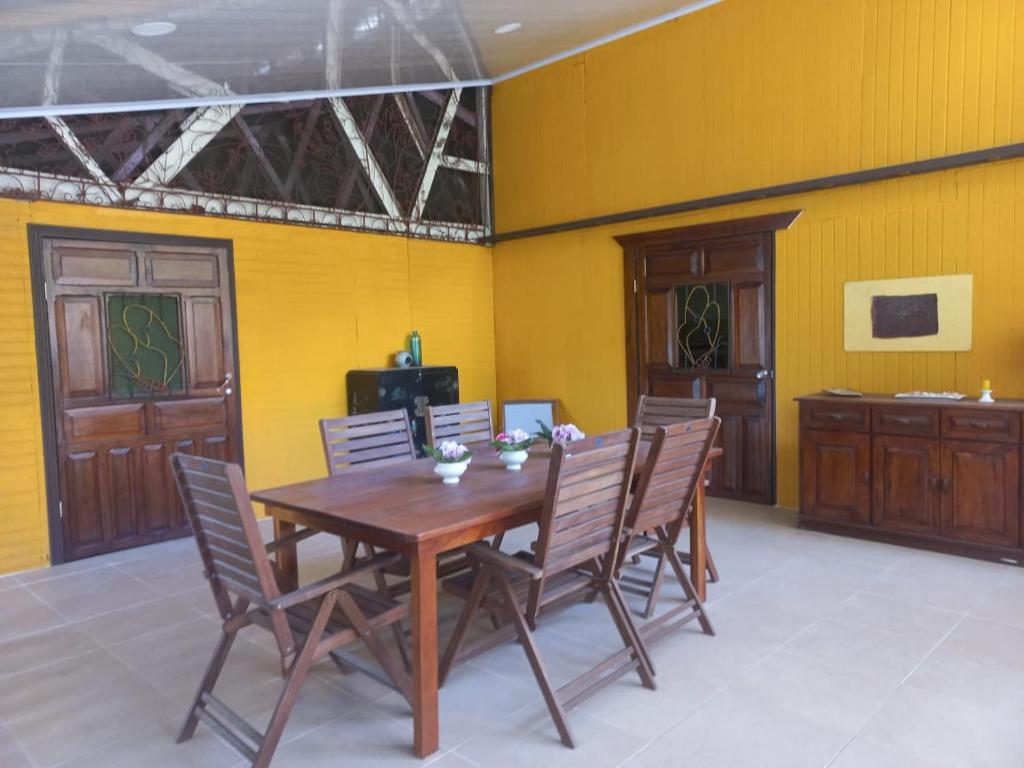 una sala da pranzo con tavolo e sedie in legno di Cabinas Coconut Grove a Puerto Viejo