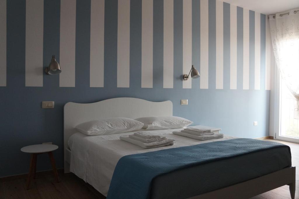 1 dormitorio con 1 cama con rayas azules y blancas en La Sperella Bed and Breakfast, en Fermo
