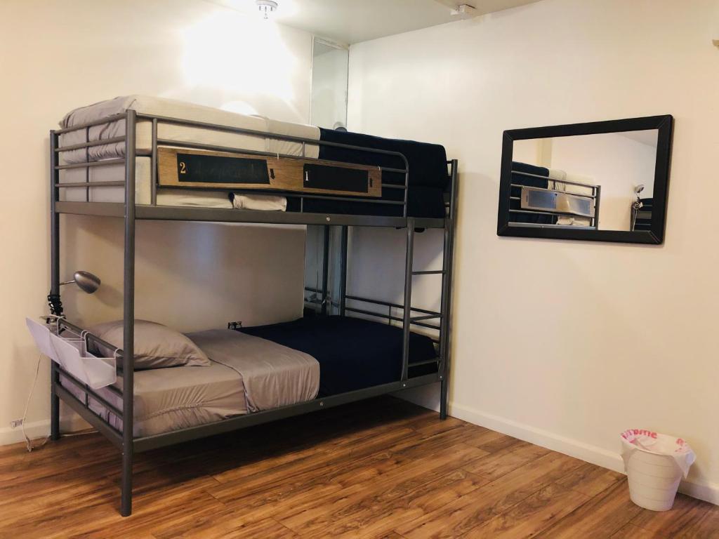 a room with two bunk beds and a mirror at Melrose Hostel in Los Angeles