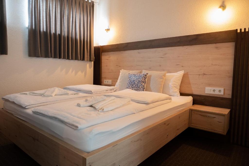 1 cama grande con sábanas blancas y almohadas. en PJ Motel Pilot en Cazin
