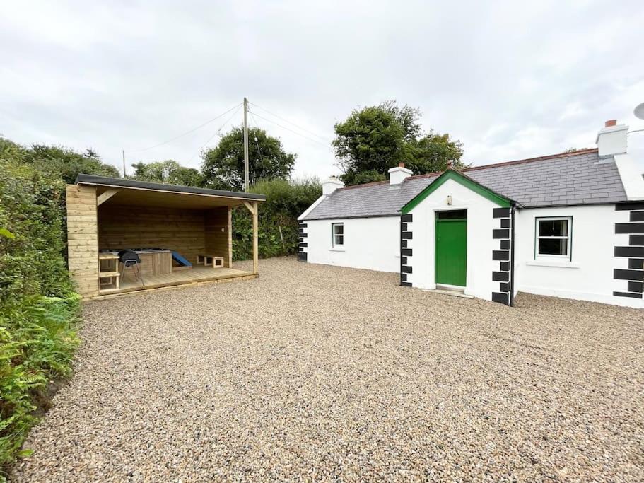 a house with a garage and a gravel driveway at John the mills cottage spaHot tub private beach in Donegal