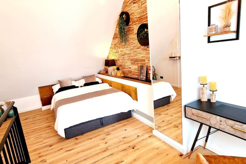 a bedroom with two beds and a brick wall at Stilvolle Maisonette Wohnung in Karlsruhe