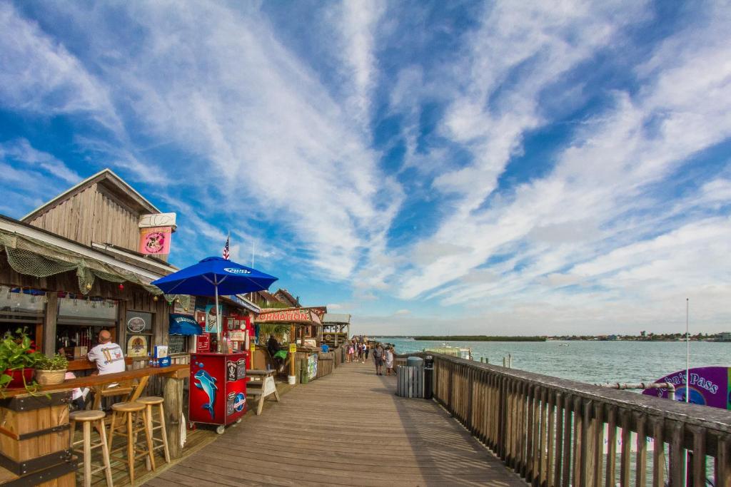 a boardwalk on the water with people walking on it at 239 Surf Song Resort in St. Pete Beach