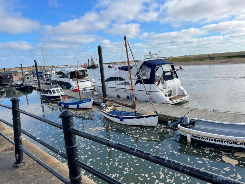 a bunch of boats are docked at a dock at Jolly Sailors Retreat in Wells next the Sea