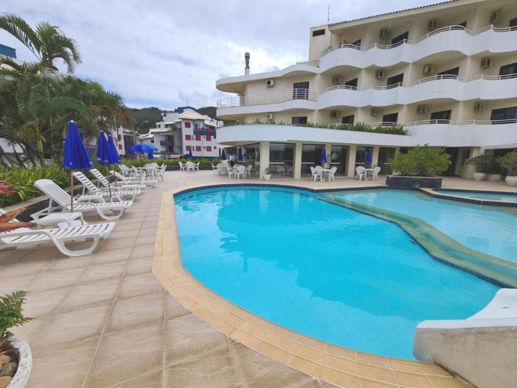 a large swimming pool in front of a hotel at Hotel Praia Brava - Studios in Florianópolis