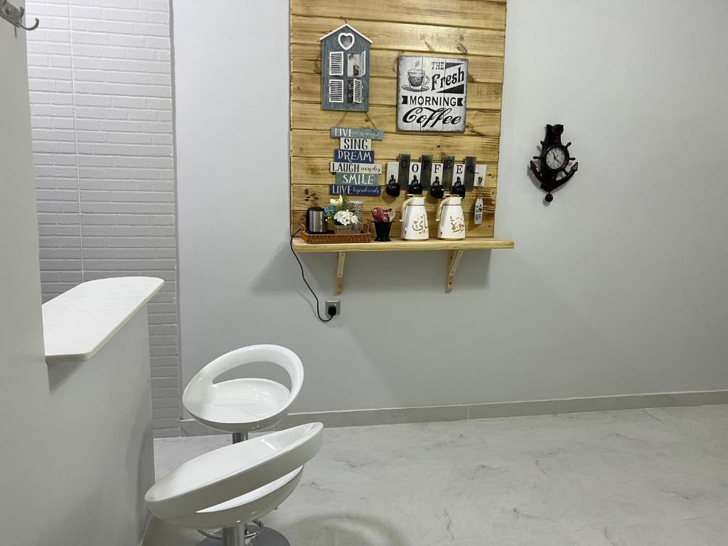 a bathroom with a toilet and a shelf with bottles of alcohol at alsaif camp in Bidiyah