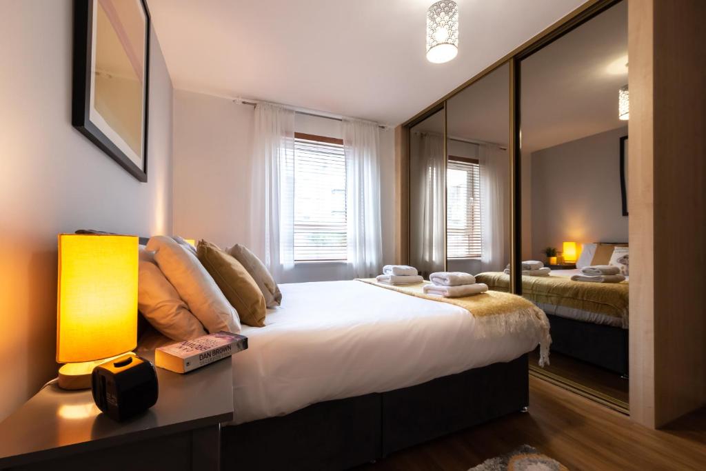 1 dormitorio con 1 cama grande y espejo grande en Black Moon -2-bed,2-bath - Central location- Southampton, en Southampton