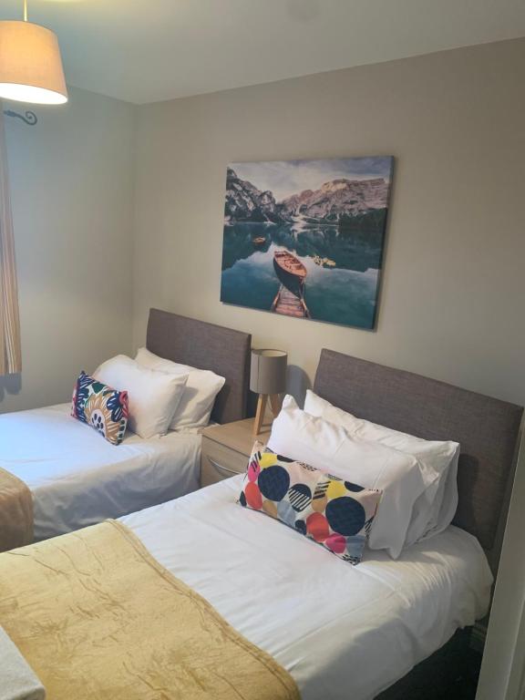 una habitación de hotel con 2 camas y un cuadro en la pared en Gravely Court en Higham Ferrers