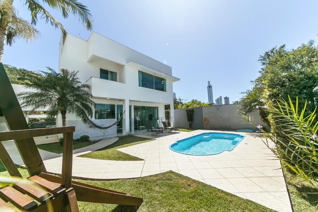 Villa con piscina frente a una casa en Casa de Praia alto Padrao, en Balneário Camboriú