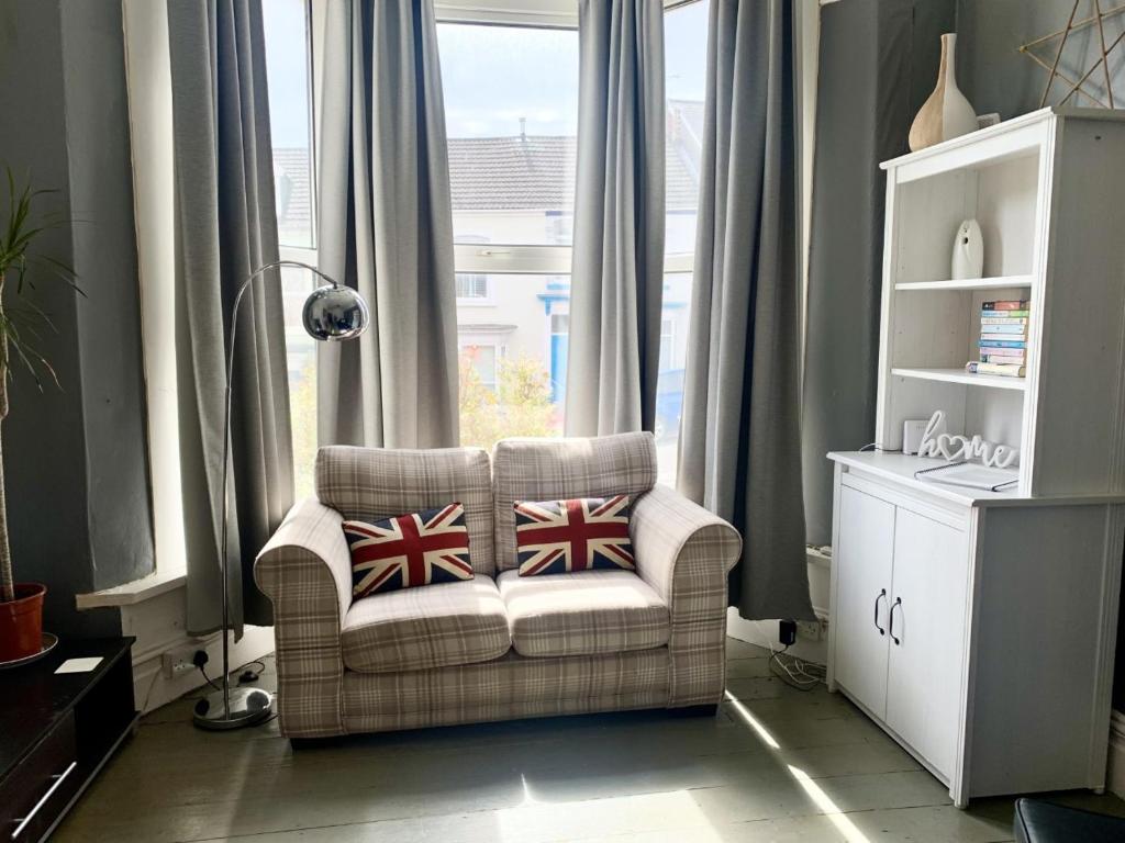 a living room with a chair and a window at F1 16 Glanmor Cres in Swansea