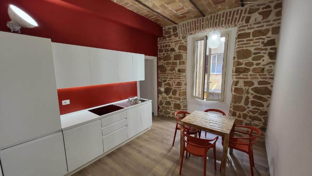 a kitchen with white cabinets and a table with chairs at Casa Volsci, 2 camere 2 bagni, Roma centro in Rome
