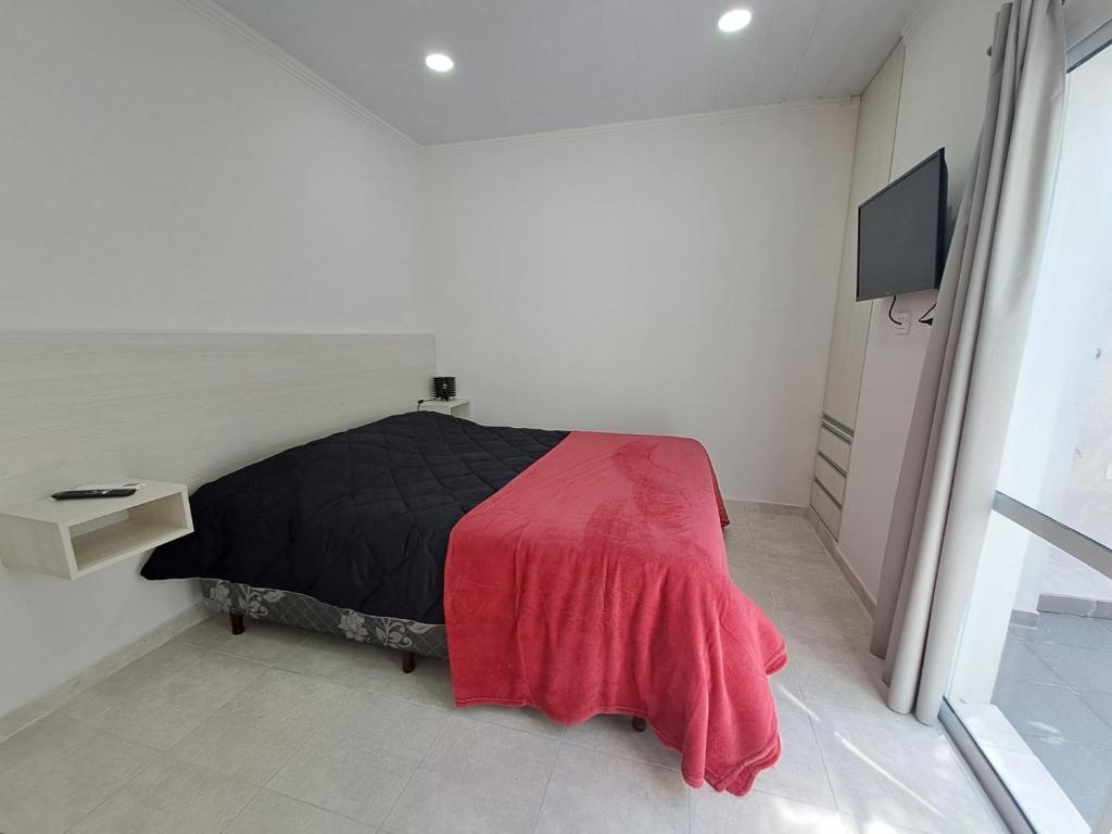 a bedroom with a bed with a red blanket on it at Pasaje Misiones in Paraná
