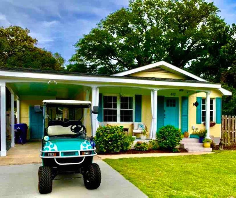 une voiturette de golf garée devant une maison dans l'établissement Downtown- Sunshine Cottage and Golf Cart, à Southport