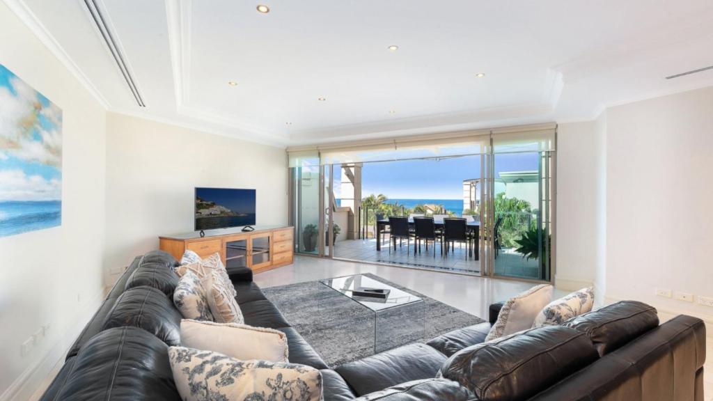 Una sala de estar con un sofá y un televisor. en Unit 46 - 3 Bed Ocean View, en Terrigal