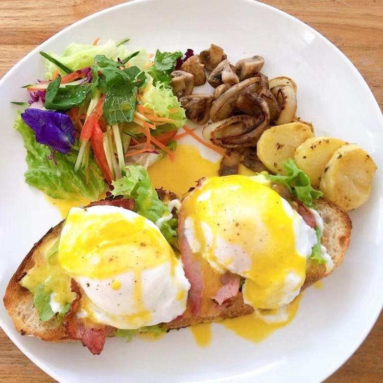 a plate of food with eggs and vegetables on a table at Metteyya Healing House in Ubud