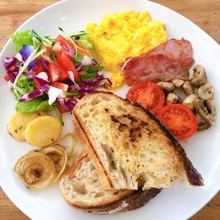 a white plate of food with a sandwich and a salad at Metteyya Healing House in Ubud