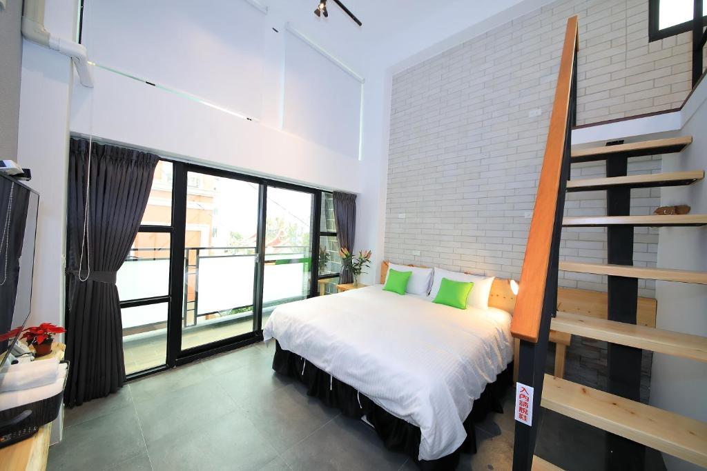 a bedroom with a large bed with green pillows at Qixingtan Xinghai B&amp;B in Dahan