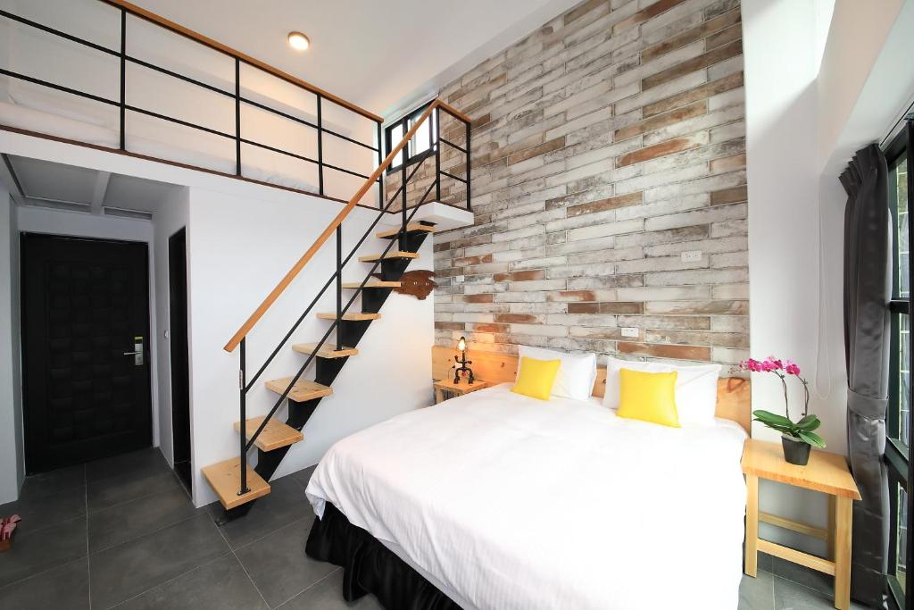 a bedroom with a bed and a brick wall at Qixingtan Xinghai B&amp;B in Dahan