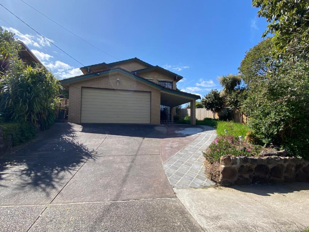 a house with a garage on the side of a driveway at ADA Homestay in Doncaster