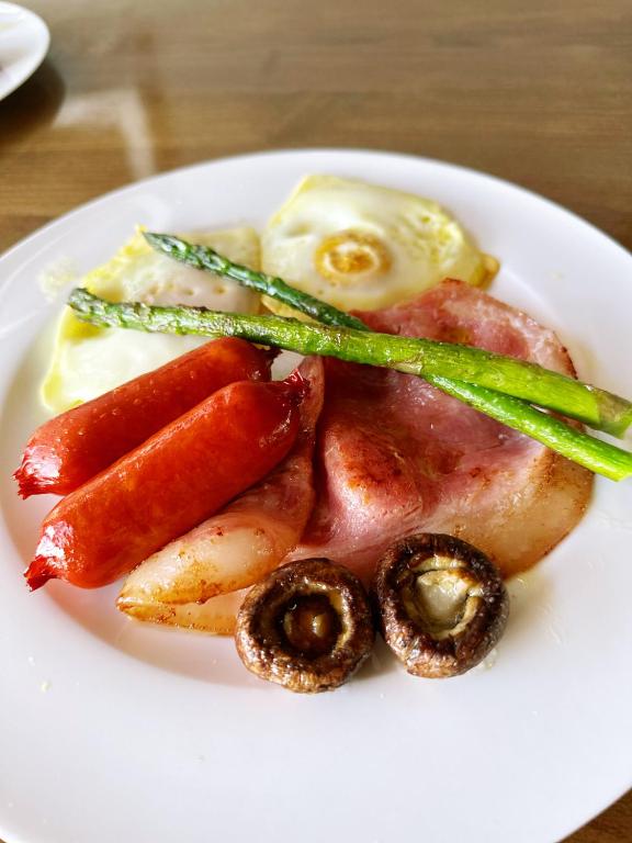 a white plate of food with meat and vegetables at Echo Lodge in Auckland