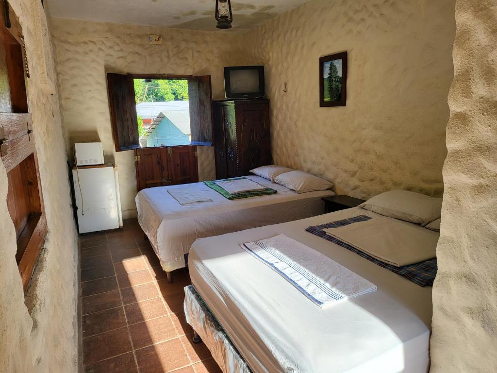 a bedroom with two beds and a window at Hostal casa de las gargolas in Amapala
