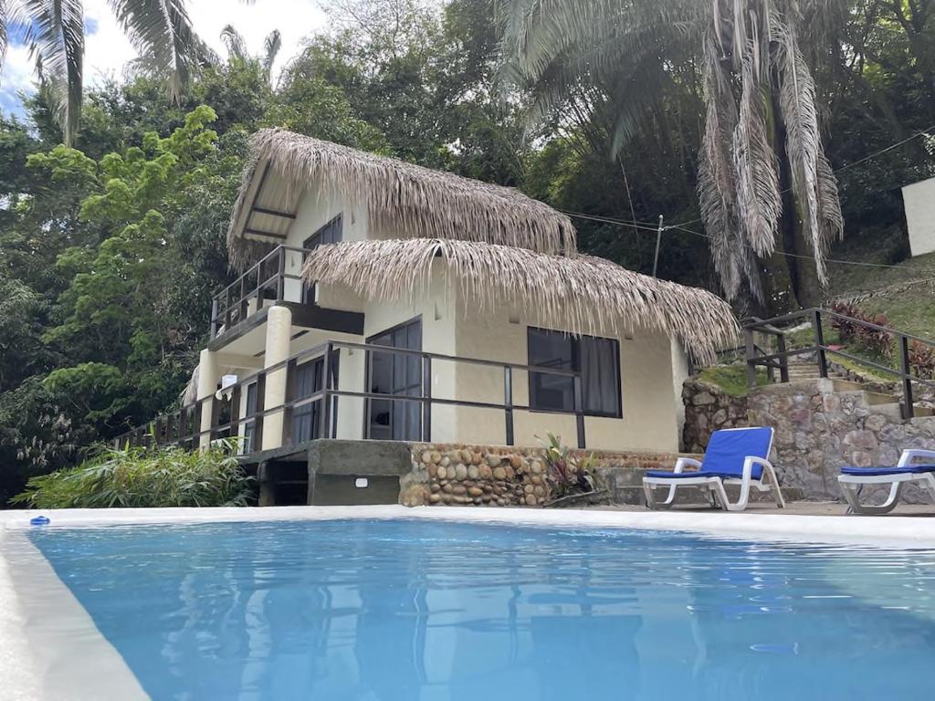 ein Haus mit einem Pool vor einem Haus in der Unterkunft Cabaña Las Palmas 