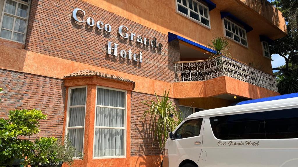 a white van parked in front of a brick building at Coco Grande Hotel in Dumaguete