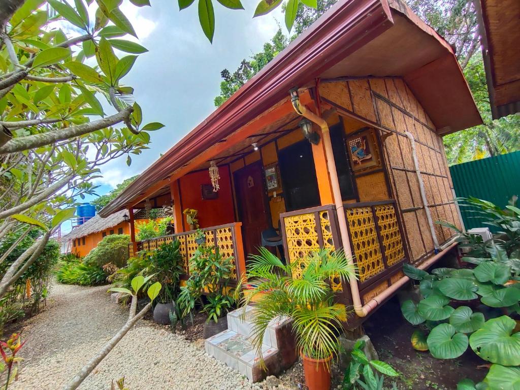 a house with a porch and plants in front of it at Adrianas Place Backpackers Hostel in Panglao Island