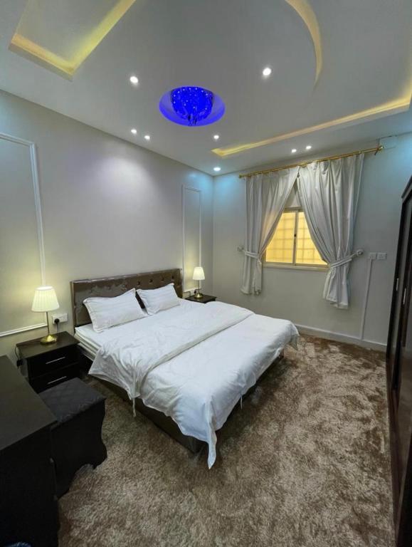 a bedroom with a large bed with a blue ceiling at شقق السودة هاوس in Suda
