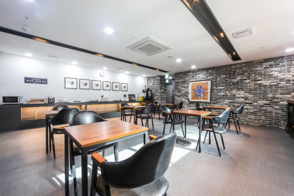 um restaurante com mesas e cadeiras e uma parede de tijolos em Seomyeon Brown-dot hotel Gold em Busan