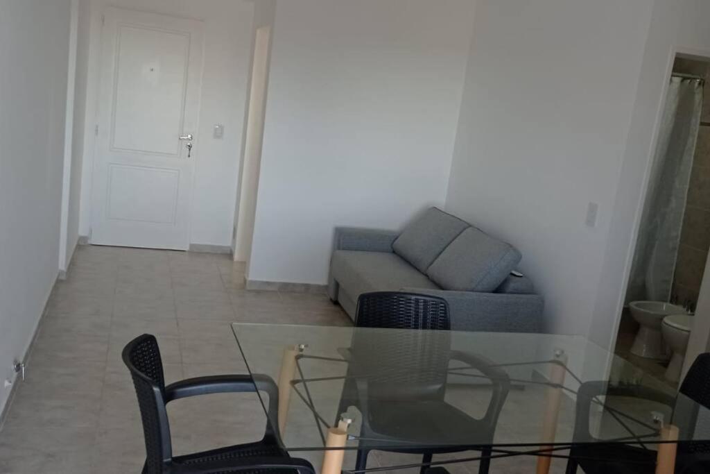 sala de estar con mesa de cristal y sillas en Departamento completo en excelente zona en Paraná