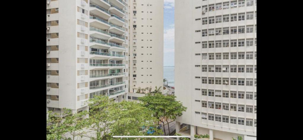 two tall white buildings standing next to each other at Lindo flat no Guarujá in Guarujá
