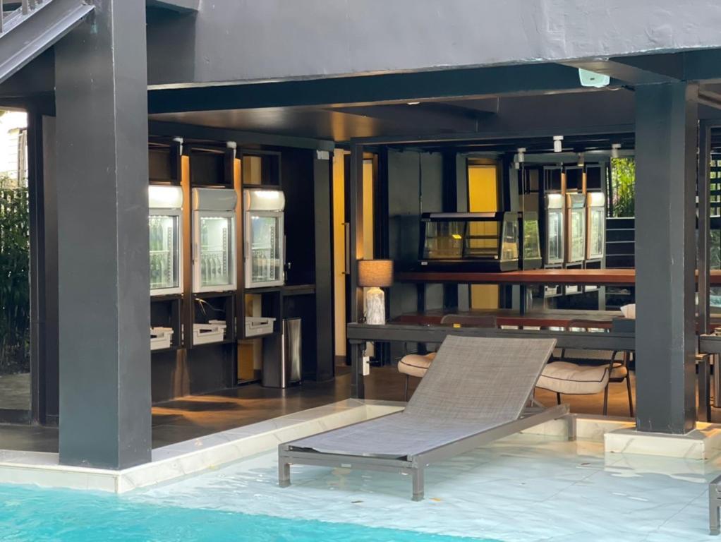 A poolside lounger's view across the shallow blue water and covered dining area.