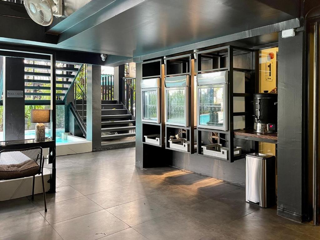 A compact communal lounge and drinks station sits beside a staircase and pool.