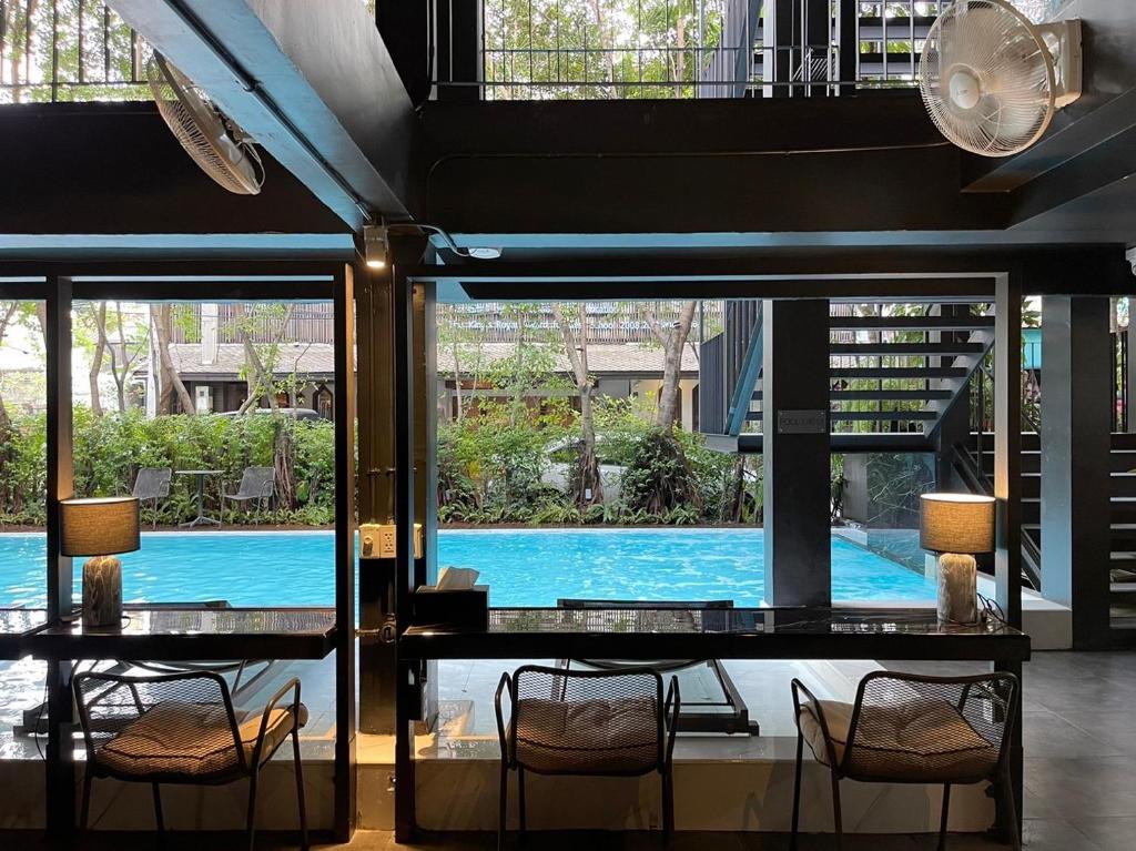 A small poolside seating area looks across the water toward landscaped grounds.