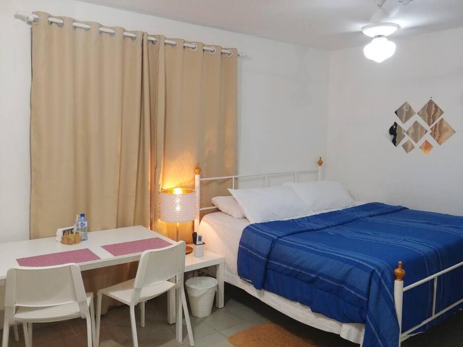a bedroom with a bed and a table and chairs at Dominican Suite 21, Amazing Apt/Studio (DS21) in San Felipe de Puerto Plata