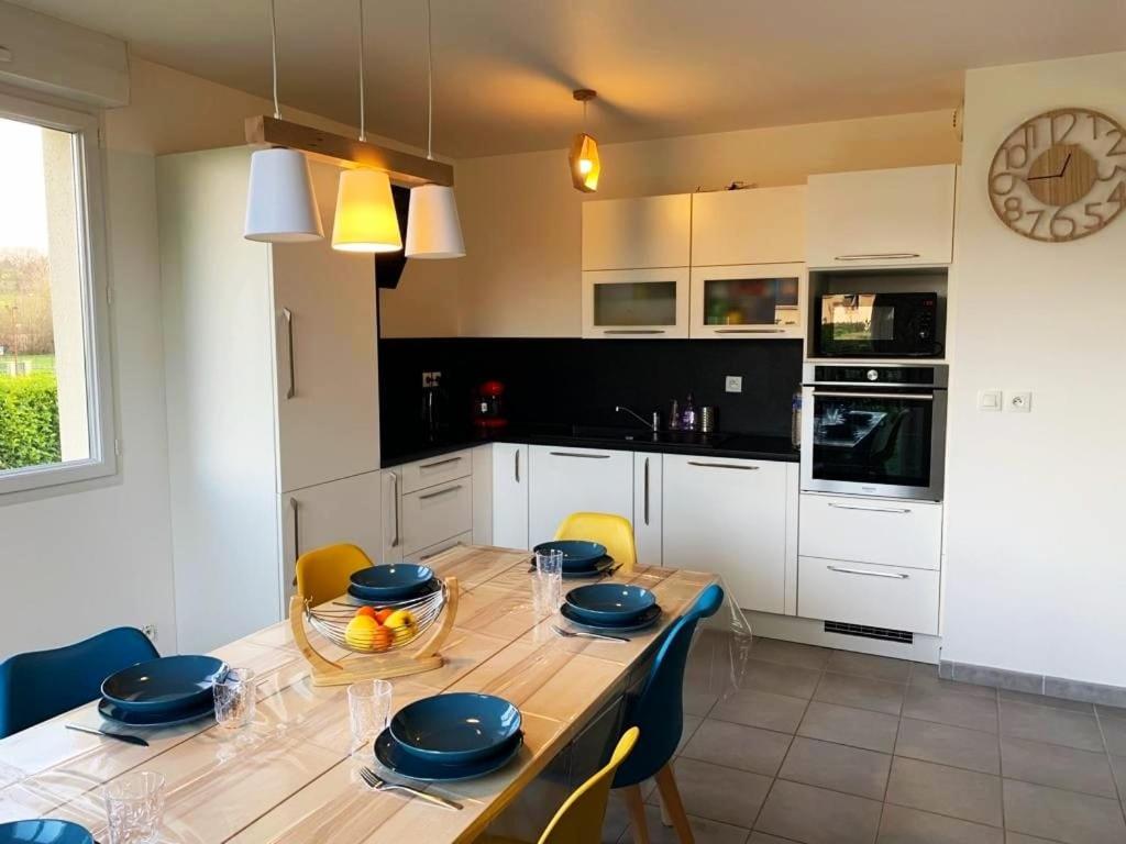 cocina con mesa de madera y comedor en Agréable maison moderne, entre campagne et mer !, en Dozulé