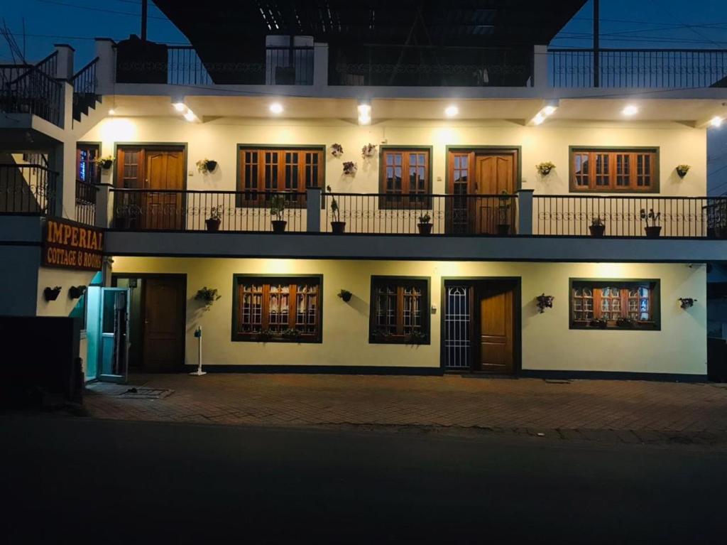 a large white building with many windows at night at IMPERIAL COTTAGE, HILL BUNK OOTY in Ooty
