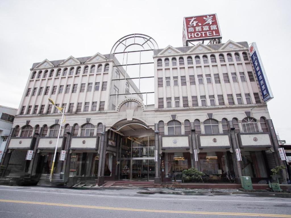 un gran edificio blanco con un cartel encima en East Coast Hotel en Hualien