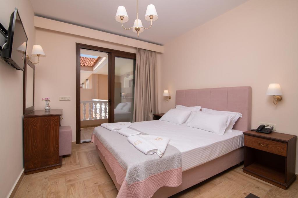 Un dormitorio con una gran cama blanca y una ventana en Zante Holidays Hotel, en Kalamaki